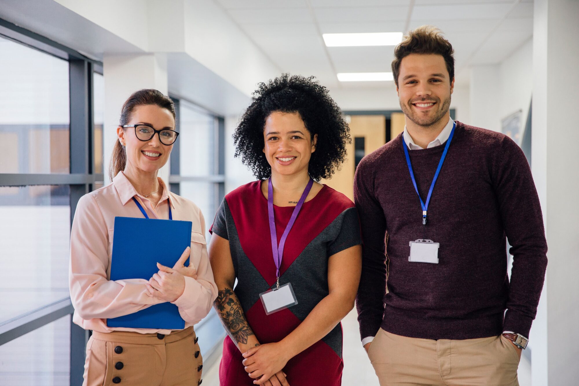3 professional teachers with lanyards smiling