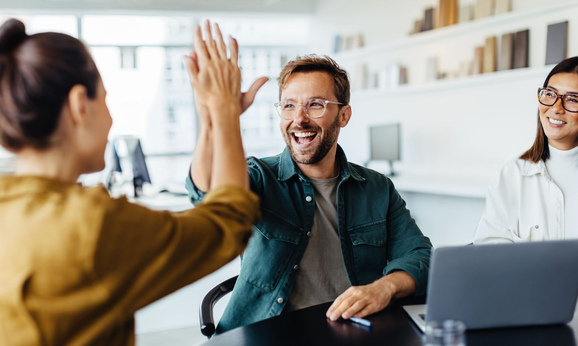two young professionals smiling and hi fiving