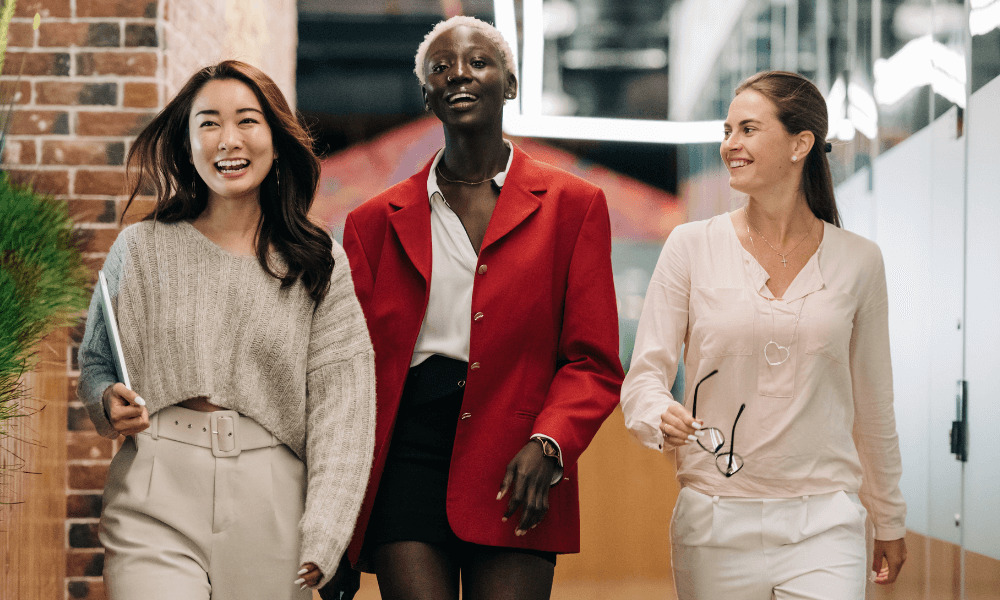 3 young woman looking smart and professional, smiling in an office