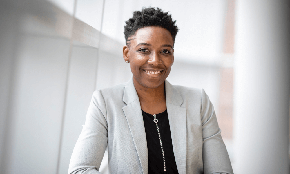 a young black woman in a suit smiling