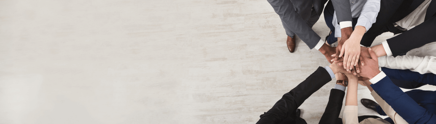 multiple hands are all together in unity, the owners of the hands are in suits